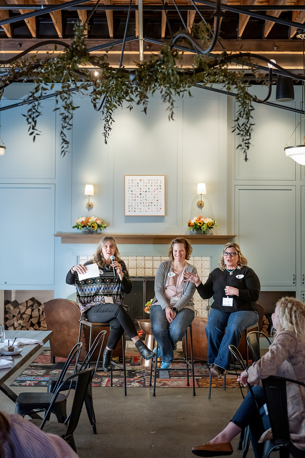 Three women sit at the front of a room.
