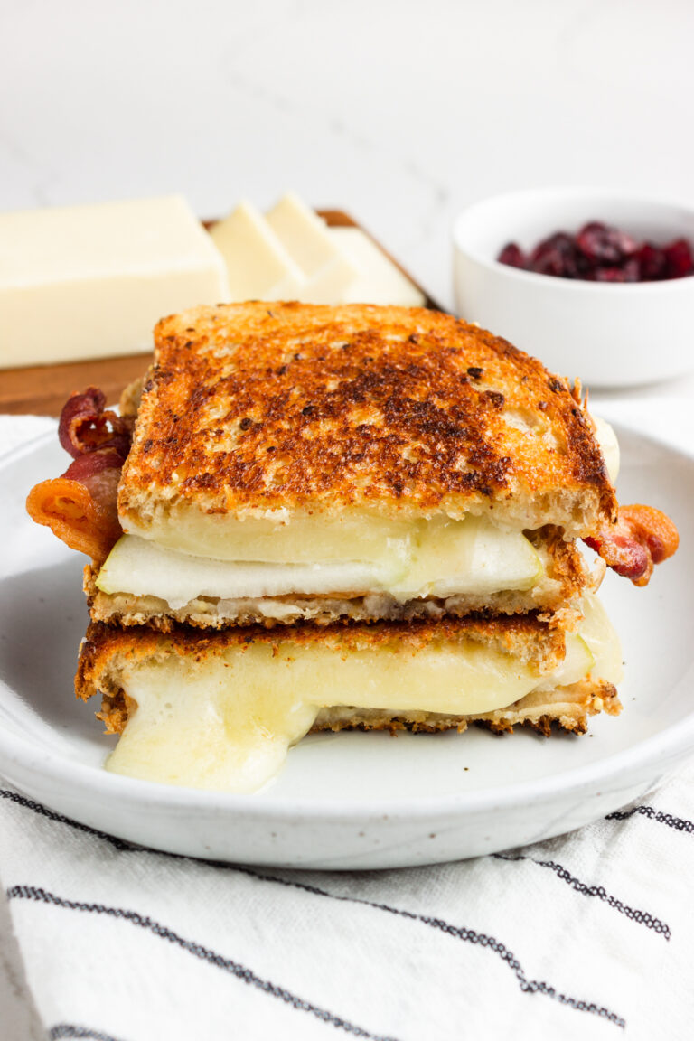A grilled cheese sandwich on a plate, on a towel.