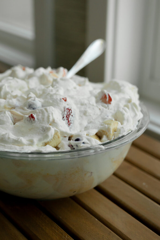 A pyrex bowl overflowing with berry dairy salad